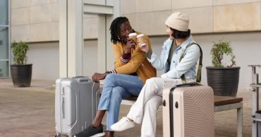 Çeşitli çiftler kahve fincanlarını kaldırıyor, kapaklarını vuruyor, gülüyor ve bavullarıyla plaza bankına yaslanıyor. Açık hava, boş zaman, yaşam tarzı, gündelik, modern, arkadaşlık, seyahat