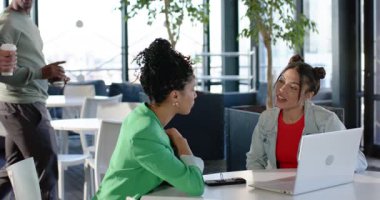 Sohbet sırasında çeşitli iş arkadaşları dizüstü bilgisayarlı akıllı telefonlarla oturma odasında oturup kahve fincanları toplantısı yapıyorlar. İşbirliği, iletişim, çeşitlilik, kentsel, profesyonel, sosyal, modern