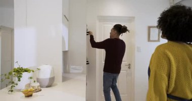 Fırının zamanlayıcısı, çeşitli çiftlerin mutfak mutfağında havluyla turta tepsisini çekerken, kabuğu incelerken çalıyor. Pişirme, pişirme, yerli, aşçı, sıcak, samimi, takım çalışması