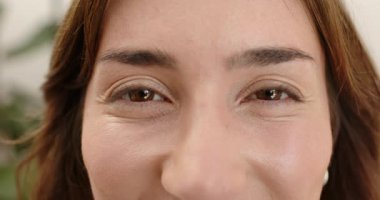 İnci küpeler takan, göz kırpan ve ince kaş hareketleri yapan bir kadın. Portre, sükunet, minimalist, güzellik, iç gözlem, sakin, profesyonel