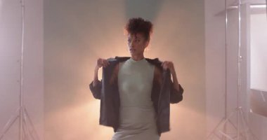 Smoky Stüdyoda deri ceket ayarlayan bir kadın, kendine güven ve tarz yayıyor. Moda, tavır, moda, fotoğrafçılık, modellik