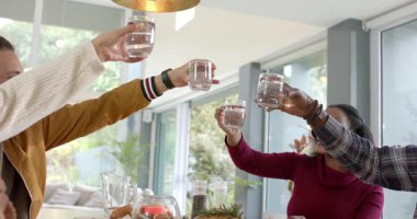 Çeşitli arkadaşlar kollarını uzatıyor, masada kadeh kaldırıyor, suyu yudumluyor, salata servisi yapıyor, fotokopi çekiyor. Kutlama, dostluk, günlük yemek, toplum, sağlık, modern, kırsal