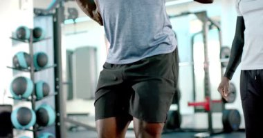 Koç, spor salonunda yedek kulübesine oturan Afrikalı Amerikalıya yol gösteriyor. Spor, spor, spor, spor, dayanıklılık, etkinlik