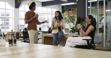 Çeşitli iş arkadaşları mola sırasında kahve fincanlarını paylaşıyor, sohbet etmeye başlıyor ve beşlik çakıyor. İşbirliği, takım çalışması, gündelik, arkadaşlık, topluluk, çeşitlilik, sohbet