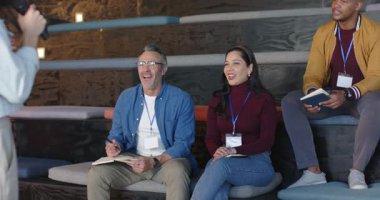 Çeşitli iş arkadaşları hoparlördeki mikrofona el çırpma tabletine not alarak tepki veriyorlar. İşbirliği, profesyonellik, katılım, yenilik, takım çalışması, iletişim, modern