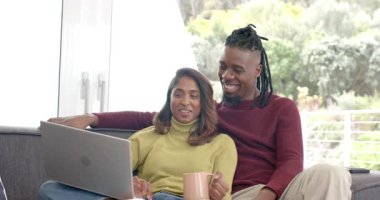 Çeşitli çiftler oturma odasında dizüstü bilgisayar açtıktan sonra kahkaha atıp içeriğe odaklandılar. İşbirliği, eğlence, modern, rahat, açık hava, iletişim, bağlantı