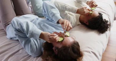 Salatalık dilimlerine uzanan farklı kadın arkadaşlar göz kapaklarını kesiyor, odada dinleniyor. Sağlık, rahatlama, dostluk, bencillik, gençleşme, kaplıca, konfor