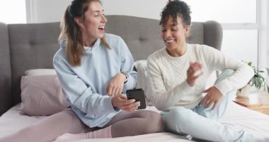 Akıllı telefon tutarak görüntüler gösteriyorsun, çeşitli bayan arkadaşlar tepki veriyor, yatak başlığı yatağında sallanıyorlar. Dostluk, rahatlık, rahatlık, yaşam tarzı, işbirliği, rahatlama, modern