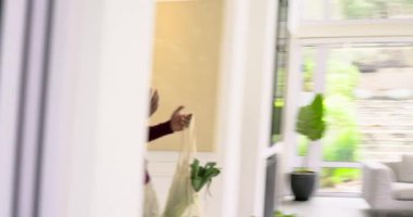 Çeşitli çiftler oturma odasının kapısını açarlar. Bakkal çantası taşırlar. Yerlerini gösterirler ve kucaklaşırlar. Modern, yaşam tarzı, iç mekan, uyum, gündelik, manzara, ilişkiler