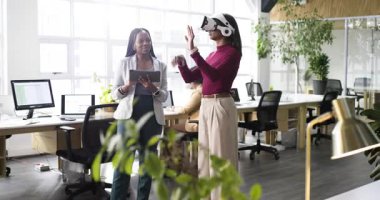 VR kulaklık takan Hintli kadın iş arkadaşı kayıt tableti olarak test kontrolleri için el kol hareketi yapıyor. Teknoloji, yenilik, işbirliği, fütürizm, çalışma alanı, dijital, iletişim