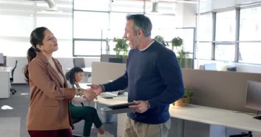 Çeşitli iş arkadaşları portföy sunduktan sonra tokalaşmaya başlayıp, ofiste karşılıklı tebessüm ediyorlar. Profesyonel, kurumsal, modern, işbirliği, ağ oluşturma, dostane, iş