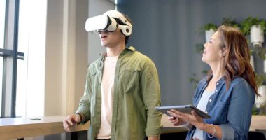 İspanyol adam VR kulaklık takıyor ve meslektaşı tablet tutarken tezgahın yanında menüleri geziyor. Teknoloji, yenilik, işbirliği, modern, dijital, eğitim, fütürist