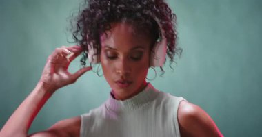 Kadın kulaklıkları ayarlıyor, stüdyoda odaklanmış ifadeyle müzikten zevk alıyor. dinleme, ses, rahatlama, eğlence