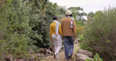 Afrika kökenli Amerikalı bir çift, odunların kenarlarında, örgü eşarplar takarak, ahşap izleri üzerinde el ele yürüyorlar. Doğa, arkadaşlık, dinginlik, keşif, açık hava, bağlantı, macera