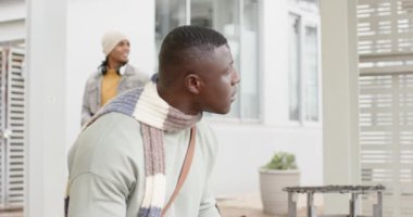 Afrika kökenli Amerikalı bir adam bavulu görüyor, akıllı telefonu alıyor ve girişte mesajlar okuyor. Şehir, banliyö, seyahat, modern, gündelik, teknoloji, yaşam tarzı