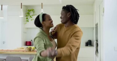 Afrika kökenli Amerikalı çiftler el üstünde dans ediyor, adanın önünde kol altında dönüp duruyorlar. Romantizm, samimiyet, bağlantı, hareket, kutlama, yaşam tarzı, ev