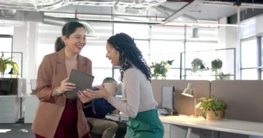 Tableti tıkırdatan ve ofisteki kahve fincanı üzerinde plan değerlendirmesini kutlayan çeşitli kadın çalışanlar. İşbirliği, takım çalışması, yenilik, iletişim, dijital, modern, üretkenlik