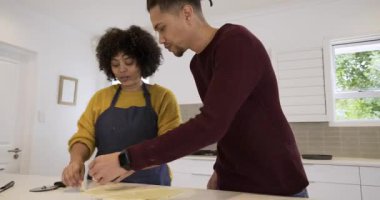 Giren adam, çeşitli çiftler mutfak adasında pasta hazırlayan kafeslere pasta şeritleri dokuyorlar. Hamur işi, pişirme, aşçılık, yaşam tarzı, kırsal, samimi, takım çalışması