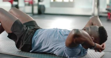 Afro-Amerikan koç işaret veriyor, müşteri egzersiz için spor paspası üzerinde mekik çekiyor, fotokopi alanı. Zindelik, kuvvet, egzersiz, motivasyon, eğitim, egzersiz, sağlık