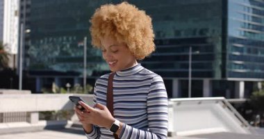 Cam binanın dışındaki terasta Afrika kökenli Amerikalı kadınların kaymasına neden olan akıllı telefon uyarısı. Kentsel, profesyonel, modern, gündelik, teknoloji, iletişim, açık hava