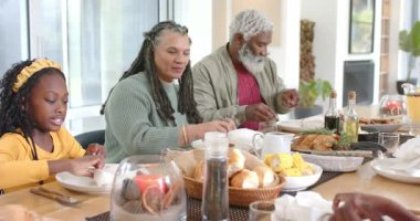 Çeşitli aileler yemek masasında beyaz bez peçeteler seriyor ve annem yemeğe başlamak için konuşuyor. Aile, konukseverlik, birliktelik, sıcaklık, iç mekan, yaşam tarzı, organik