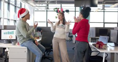 Çeşitli iş arkadaşları, bayram neşesi için ofisin başındaki boynuzlu kadını alkışlıyor. Kutlama, takım çalışması, yoldaşlık, festival, işbirliği, neşeli, çağdaş