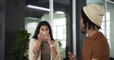 Hintli kadın elinde kahve fincanıyla ofise giriyor. Siyahi adamı plan için son teslim tarihlerini anlatırken dinliyor. İşbirliği, iletişim, profesyonellik, modernlik, takım çalışması, çalışma alanı, meşgul