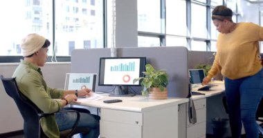 Akranların akıllı telefonla yaklaşması üzerine çeşitli çalışma arkadaşları masa çizelgelerini analiz ediyor. İşbirliği, veri, analiz, takım çalışması, modern, profesyonel, üretkenlik