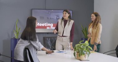 Çeşitli bayan meslektaşlar el sıkışıyor, el sallıyor, vedalaşıyor, masadaki belgeleri inceliyor. Profesyonel, işbirliği, şirket, modern, takım çalışması, iletişim, iş