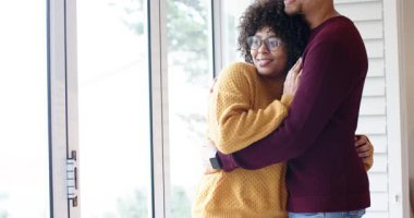 Çeşitli çiftler sevgi paylaşmak için oturma odasındaki cam kapıyı sürgüleyerek kucaklaşırlar. Romantizm, samimiyet, şefkat, iç mekan, konfor, bağlantı, huzur