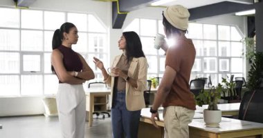 Çeşitli iş arkadaşları ellerinde kahve fincanı ile ofisteki tartışmalara başlıyorlar jest yapıyorlar, dinliyorlar ve yudumluyorlar. İşbirliği, takım çalışması, iletişim, profesyonel, modern, gayri resmi, çalışma alanı