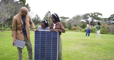 Aile oryantasyonu küçük ve büyük güneş panelleri çimenlik güneş hizasını gösteriyor. Sürdürülebilir, yenilenebilir, teknoloji, eğitim, açık hava, çevre dostu, doğal