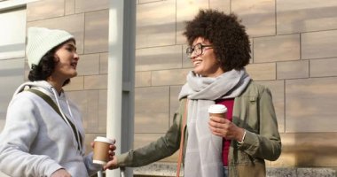 Çeşitli bayan arkadaşlar ellerinde kahve fincanları ve kaldırımda bavullarını taşırken sohbet ediyorlar. Kentsel, arkadaşlık, günlük, yaşam tarzı, modern, seyahat, bağlantı