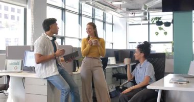 Tablet tıkırtılarını gösteriyor. Ofisteki çeşitli iş arkadaşları kahkahalarla kahkahalarla kahkahalar atıyor. İşbirliği, takım çalışması, yenilik, profesyonel, gündelik, modern, çalışma alanı