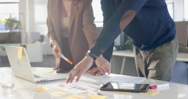 Çeşitli iş arkadaşları açık ofiste buluşup çizelgeleri turuncu kalemle işaretleyerek eğilimleri analiz ediyorlar. İşbirliği, takım çalışması, analitik, beyin fırtınası, profesyonel, modern, üretkenlik