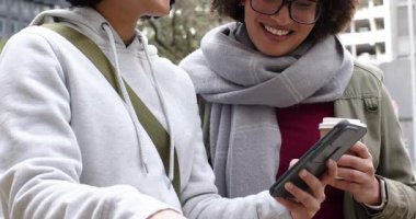 Kaldırımda scooter 'ı gören çeşitli bayan arkadaşlar telefon haritasını kontrol ediyor ve kahve fincanı tutuyor. Kentsel, dostluk, teknoloji, keşif, gündelik, stil, metropol