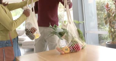 Çeşitli çiftler mutfak poşetlerini pencerelerin yanındaki ahşap masaya boşaltıp akşam yemeği hazırlıyorlardı. Çevre dostu, sürdürülebilirlik, taze üretim, yerli, samimi, modern, doğal ışık