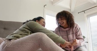 Anne ve kızı yatakta gıdıklanıyor kıkırdıyor, kıkırdıyor, eğiliyor, hafifçe okşuyor ve gülümsüyor. Aile, şefkat, bağ, samimi, samimi, samimi, neşeli