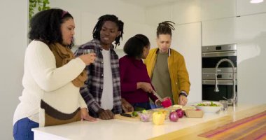 Mutfak adasında biber doğrayan çeşitli arkadaşlar grup selfie 'sini çekmek için akıllı telefon sallıyorlar. Grup, sosyal, kutlama, yaşam tarzı, samimi, modern, canlı