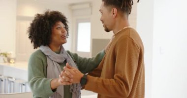 Elini yukarı kaldırdıktan sonra romantik bir çift açık mutfakta dans ediyor. Adadan adaya, neşeyi paylaşıyor. Romantizm, samimiyet, kutlama, dans, arkadaşlık, modern, samimi