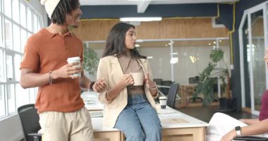 Geldikten sonra, çeşitli iş arkadaşları kahve molası sırasında ellerinde bardak ve fincanlarla sohbet ediyorlar. İşbirliği, iletişim, profesyonellik, gündelik, kurumsal, meslektaş, takım çalışması