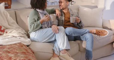 Birbirlerine bakıyorlar, seramik bardakları yudumluyorlar ve gri kanepede kahkahalarla kaynaşıyorlar. Samimiyet, arkadaşlık, rahatlık, rahatlama, ev, sıcaklık, samimiyet.