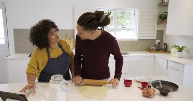 Mutfak adasında merdaneyle hamuru düzleştiren çeşitli tablet tarifleri kullanarak. Aşçılık, aşçılık, modern, yaşam tarzı, işbirliği, sıcak, çekici.