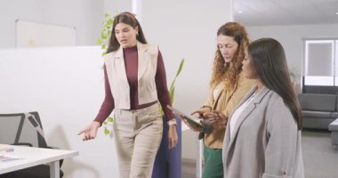 Tablete gülen çeşitli iş arkadaşları açık planlı ofiste bunu gösteren kıvırcık saçlı meslektaşlar gibi. İşbirliği, takım çalışması, çeşitlilik, profesyonel, iletişim, yenilik, modern