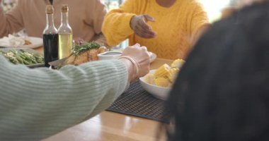 Afro-Amerikan kadın olarak çeşitli aileler yemek masasında mısırdan tavuğa geçerek fasulye kepçeliyor. Aile toplantısı, ev yemeği, aşçılık, sağlıklı, kırsal, mevsimlik, besleyici