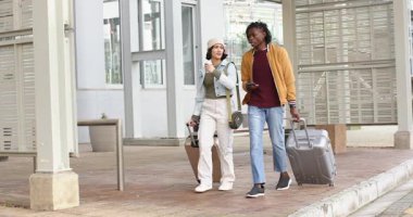 Ulaşım terminalinde yürüyen çeşitli arkadaşlar bavullarını çekip akıllı telefonları kontrol ediyorlar. Seyahat, kentsel, gündelik, modern, yaşam tarzı, keşif, hareketlilik