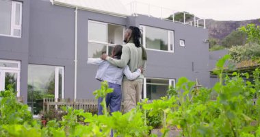 Gri ev bahçesini keşfeden, pencereleri gösteren, taşınmadan önce kucaklaşan farklı çiftler. Romantik, banliyö, modern, mimari, manzara, bağlantı, sükunet