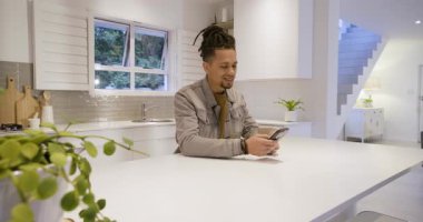 Beyaz Ada 'da akıllı telefonu eline alan orta yaşlı bir adam gülümserken kayıyor ve şaşırıyor. Modern, yaşam tarzı, samimi, açık çekim, dijital, gündelik, ev