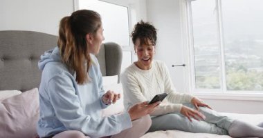 Akıllı telefonu arkadaşa çevirmek, çeşitli bayan arkadaşların yatak odasında kıvrılıp tartışıp tartışması. Yoldaşlar, rahatlık, konfor, modern, iletişim, yaşam tarzı, gündelik