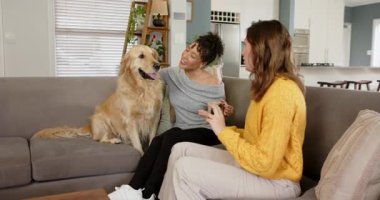 Gülen, çeşitli bayan arkadaşlar kanepeye Golden Retriever 'ı seviyorlar ve selfie için akıllı telefon kaldırıyorlar. Arkadaşlık, arkadaşlık, konfor, yaşam tarzı, sıcaklık, rahatlama, sevgi dolu.